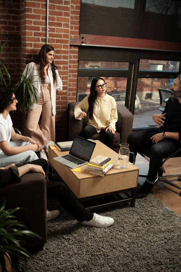 Des employés discutent autour d'une table basse au bureau.