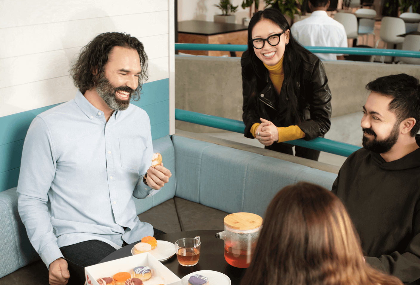 Team having a well-deserved break around donuts and tea